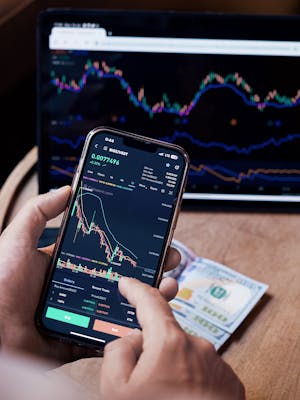 Man Looking at the Stock Charts on the Phone and Tablet